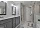 Well-lit bathroom featuring double sinks, white marble floors, and gray cabinets at 2112 Highway 54, Moreland, GA 30259
