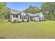 Exterior view of home with manicured lawn, mature trees, and black shutters providing a welcoming feel at 2112 Highway 54, Moreland, GA 30259