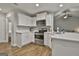 Modern kitchen showcasing white cabinets, stainless appliances, quartz counters, and hardwood floors at 2112 Highway 54, Moreland, GA 30259