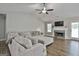Comfortable living room with fireplace, large sectional sofa, ceiling fan and hardwood floors at 2112 Highway 54, Moreland, GA 30259