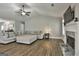 Open living room featuring a ceiling fan, fireplace, hardwood floors and large comfortable sectional at 2112 Highway 54, Moreland, GA 30259