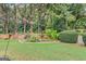 Private backyard featuring a brick wall, gardening area and mature trees at 157 Glen Eagle Way, Mcdonough, GA 30253