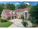 Elegant brick home featuring a circular driveway and lush landscaping at 157 Glen Eagle Way, Mcdonough, GA 30253