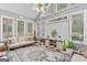 Inviting sunroom features abundant natural light, comfortable sofa, and stylish rug at 157 Glen Eagle Way, Mcdonough, GA 30253