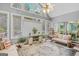 Light-filled sunroom with vaulted ceiling, large windows, and cozy seating area at 157 Glen Eagle Way, Mcdonough, GA 30253