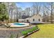 Backyard with an in-ground pool, chairs, patio, grass, and wooded perimeter at 313 Dingler Rd, Moreland, GA 30259