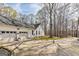 Home's exterior with a two-car garage and paved driveway situated on a large wooded lot at 313 Dingler Rd, Moreland, GA 30259