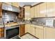 Close-up of kitchen features stainless steel appliances, granite countertops, and cream and brown cabinets at 313 Dingler Rd, Moreland, GA 30259