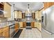 Well-lit kitchen with stainless steel appliances, granite countertops, cream and brown cabinets, and tile flooring at 313 Dingler Rd, Moreland, GA 30259