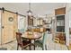 This charming kitchen and dining area features tile flooring, a sliding barn door, and unique light fixtures at 313 Dingler Rd, Moreland, GA 30259