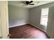 This bedroom boasts warm hardwood floors, a ceiling fan, and a sunlit window at 40 Canterbury Dr, Grantville, GA 30220