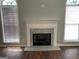 Bright living room featuring a fireplace with granite surround, two windows with blinds, and hardwood floors at 40 Canterbury Dr, Grantville, GA 30220
