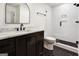 Bathroom featuring dark vanity with marble countertop, black hardware, glass shower door, and black tile floors at 434 Selborne Way, Chattahoochee Hills, GA 30268