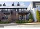 Townhome exterior featuring brick, balconies, black railings, chimneys, and a landscaped yard at 434 Selborne Way, Chattahoochee Hills, GA 30268