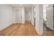 View of a hallway with hardwood flooring, white doors and walls, and bathroom at 434 Selborne Way, Chattahoochee Hills, GA 30268