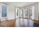 Sunlit living room featuring hardwood floors, large windows, and elegant white curtains at 434 Selborne Way, Chattahoochee Hills, GA 30268