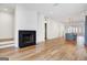 Bright living room with a modern fireplace and hardwood flooring, open to kitchen at 434 Selborne Way, Chattahoochee Hills, GA 30268
