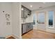 Mudroom features gray cabinetry, stainless steel dishwasher, sink, and access to the outdoors at 434 Selborne Way, Chattahoochee Hills, GA 30268