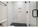 Bathroom showcasing a white tile shower with matte black hardware and black hexagon tile floors at 434 Selborne Way, Chattahoochee Hills, GA 30268