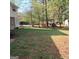 Large backyard with shed in the distance, partially shaded by mature trees at 6521 King William Dr, Morrow, GA 30260