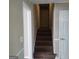 Carpeted staircase leading to the upper level of the home, adjacent to doorways at 6521 King William Dr, Morrow, GA 30260