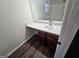 Bathroom vanity featuring dark wood cabinets, a white countertop, and stainless steel faucet with modern fixtures at 1857 Oak Hill Springs Blvd, Lithonia, GA 30058