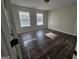 Spacious bedroom featuring dark wood floors and natural light from two windows at 1857 Oak Hill Springs Blvd, Lithonia, GA 30058