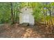 Rustic backyard shed with white paint, surrounded by a shady canopy of mature trees at 60 Charlotte Blvd, Stockbridge, GA 30281