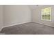 Cozy bedroom with neutral walls and carpet, featuring a bright window providing natural light at 60 Charlotte Blvd, Stockbridge, GA 30281