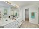 Bright bathroom featuring a double vanity, a shower, and a separate walk-in closet for ample storage at 249 Edenwylde Ct, Hampton, GA 30228