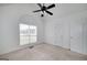 Light-filled bedroom featuring neutral carpet, a ceiling fan, and large windows at 249 Edenwylde Ct, Hampton, GA 30228