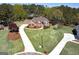 Aerial view of a brick home with lush landscaping, a long driveway, and a sparkling swimming pool at 249 Edenwylde Ct, Hampton, GA 30228