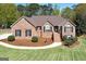 Charming brick home featuring a landscaped front yard, garden beds, and a welcoming entrance staircase at 249 Edenwylde Ct, Hampton, GA 30228