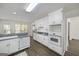 Bright, galley-style kitchen with white appliances, view of backyard, and hardwood floors at 249 Edenwylde Ct, Hampton, GA 30228