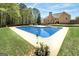 Backyard in-ground pool surrounded by a concrete deck, lush green lawn, and a beautifully landscaped yard at 249 Edenwylde Ct, Hampton, GA 30228