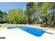 Bright blue swimming pool nestled in a private backyard with lush landscaping and a wooden fence at 249 Edenwylde Ct, Hampton, GA 30228