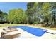 Backyard swimming pool with lounge chairs on the pool deck at 249 Edenwylde Ct, Hampton, GA 30228