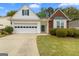 Charming home featuring a one-car garage, lovely lawn and manicured shrubs at 161 Spring Creek Blvd, Mcdonough, GA 30253