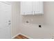 Bright laundry area with connections, white cabinets, and convenient door access at 161 Spring Creek Blvd, Mcdonough, GA 30253