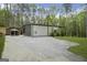 Modern home exterior featuring a large concrete driveway and additional gazebo structure at 803 Bentley Hill Rd, Stockbridge, GA 30281