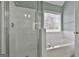 Bright bathroom showcasing a glass door shower and a separate soaking tub near a window at 198 Crestwood Rd, Tyrone, GA 30290