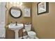 Half bathroom features a pedestal sink, decorative mirror, and stylish fixtures at 198 Crestwood Rd, Tyrone, GA 30290