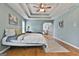 Bright bedroom showing tray ceilings, hardwood floors, and an arched entry way to living room at 198 Crestwood Rd, Tyrone, GA 30290