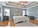 Comfortable bedroom featuring light blue walls, tray ceiling, and beautiful hardwood floors at 198 Crestwood Rd, Tyrone, GA 30290