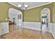 Dining room with wainscoting, open to a living room, and arched doorways at 198 Crestwood Rd, Tyrone, GA 30290