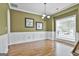 Spacious dining room with wainscoting, large window, and modern chandelier at 198 Crestwood Rd, Tyrone, GA 30290