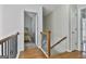 Upstairs hallway with hardwood floors and access to bedrooms, featuring a wooden staircase at 198 Crestwood Rd, Tyrone, GA 30290