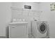 Functional laundry room equipped with a modern washer, dryer, and overhead shelving for storage at 198 Crestwood Rd, Tyrone, GA 30290