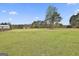 Expansive grassy yard with mature trees, outbuildings, and a glimpse of the home at 198 Crestwood Rd, Tyrone, GA 30290