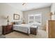 Comfortable bedroom with neutral tones, featuring a decorative trunk and ample natural light from a window at 5124 N Pratt St, Covington, GA 30014